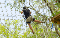 Man Climbing Net On Black Storm Course